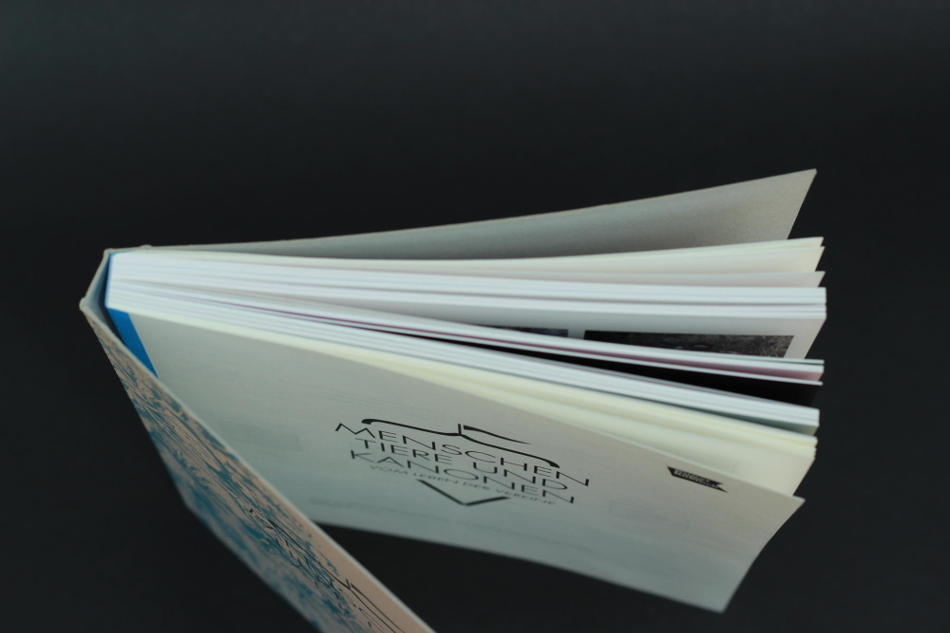 Schweizer Broschur mit einem farbigem Fälzelband (Irisleinen), Umschlag wurde auf Maschinengraukarton 500g gedruckt